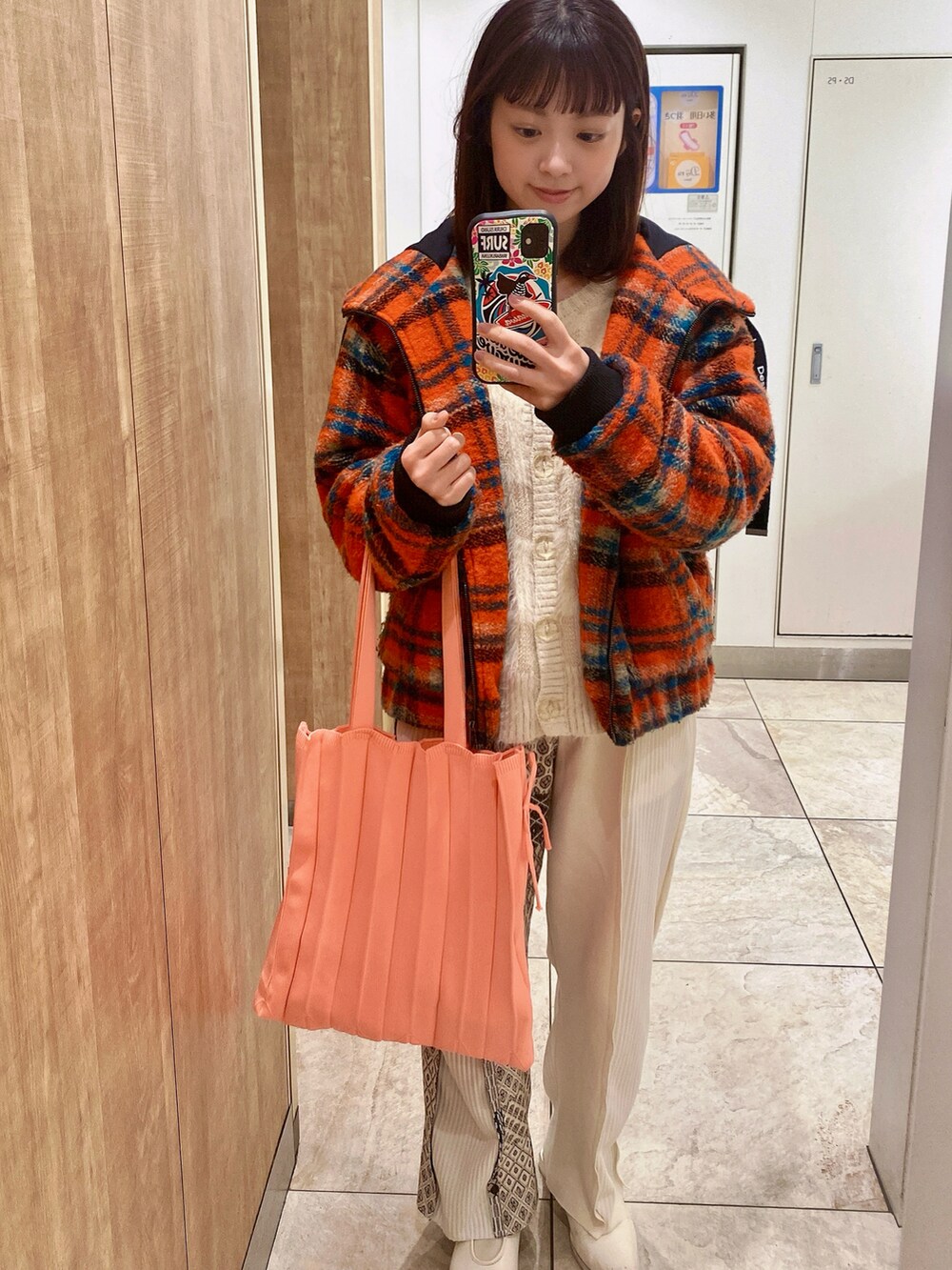 ホワイト系のニット/セーター、ホワイト系のパンプス、オレンジ系のジャケット/アウターを着用したレディースの冬コーディネートの2枚目の写真