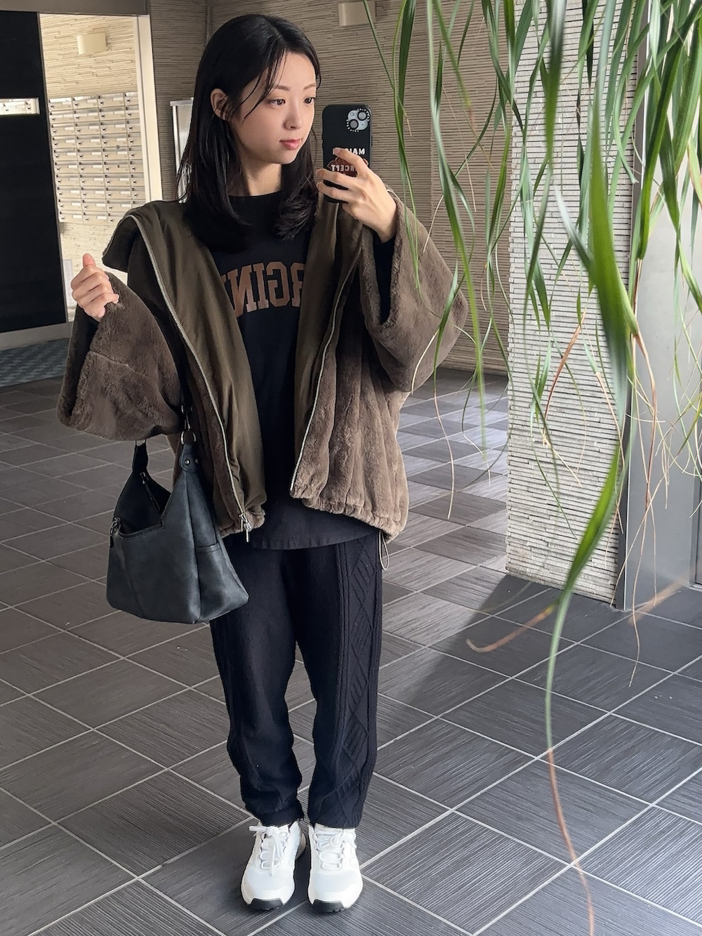 ブラック系のトップス、ブラウン系のブルゾンを着用したレディースの冬コーディネートの2枚目の写真