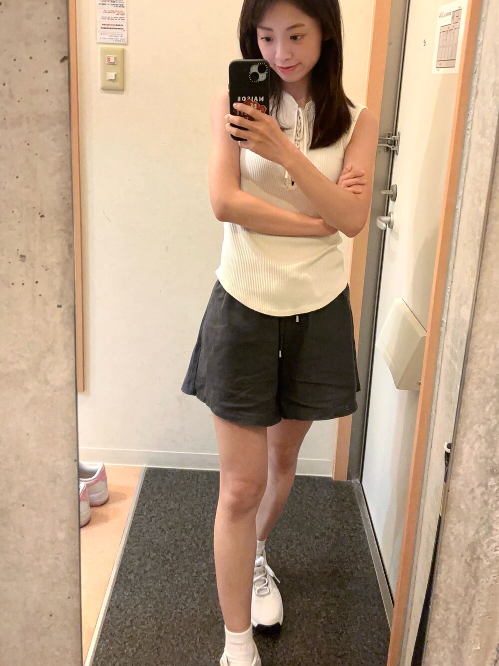 ホワイト系のタンクトップ、グレー系のパンツを着用したレディースの秋コーディネートの2枚目の写真