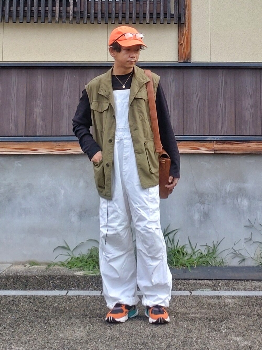 グリーン系のベスト、ホワイト系のサロペット/オーバーオール、ブラック系のスニーカーを着用したメンズの夏コーディネートの3枚目の写真