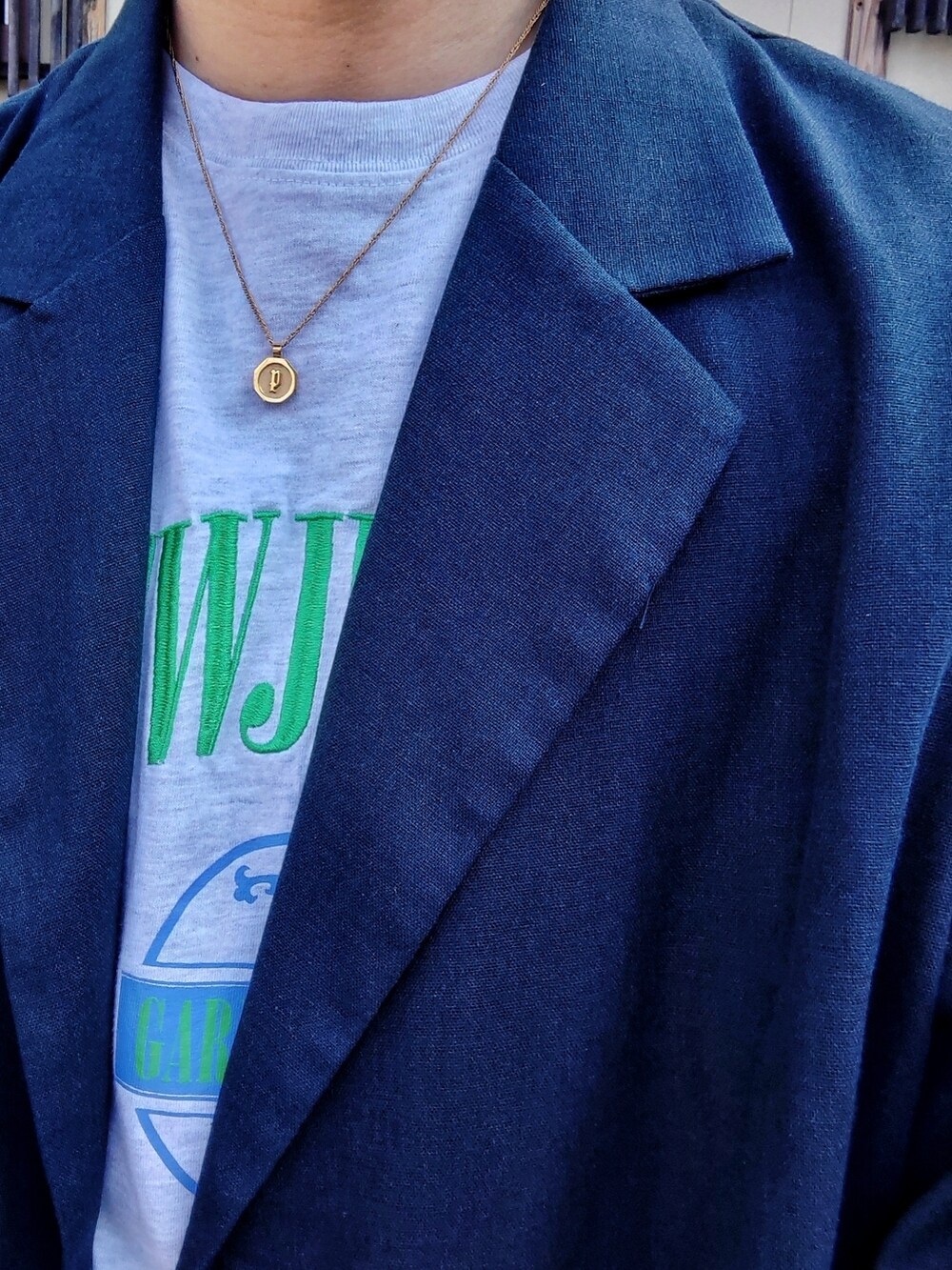 グリーン系のカーゴパンツ、ベージュ系のTシャツ/カットソー、ブルー系のテーラードジャケットを着用したメンズの夏コーディネートの2枚目の写真