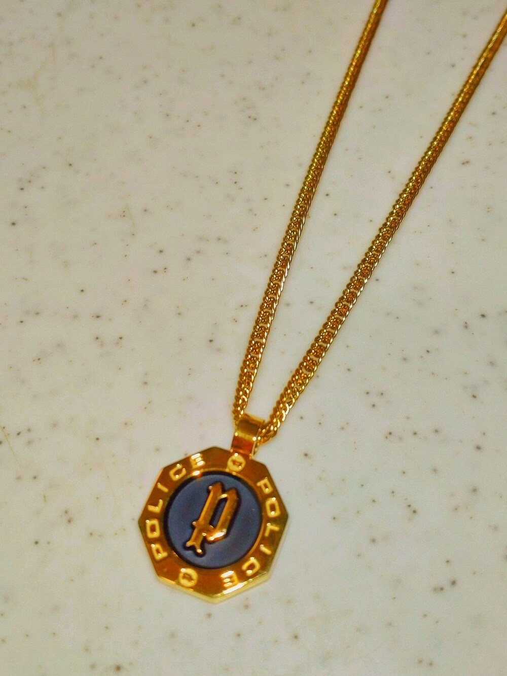 パープル系のスウェット、ブラウン系のスラックス、ゴールド系のネックレスを着用したメンズの春コーディネートの2枚目の写真