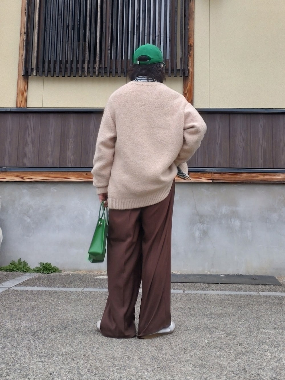 ベージュ系のカーディガン/ボレロ、ブラウン系のスラックス、グリーン系のショルダーバッグを着用したメンズの春コーディネートの2枚目の写真