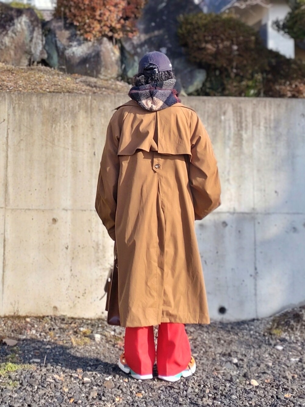 ブルー系のパーカー、レッド系のスラックス、ブラウン系のトートバッグを着用したメンズの冬コーディネートの2枚目の写真