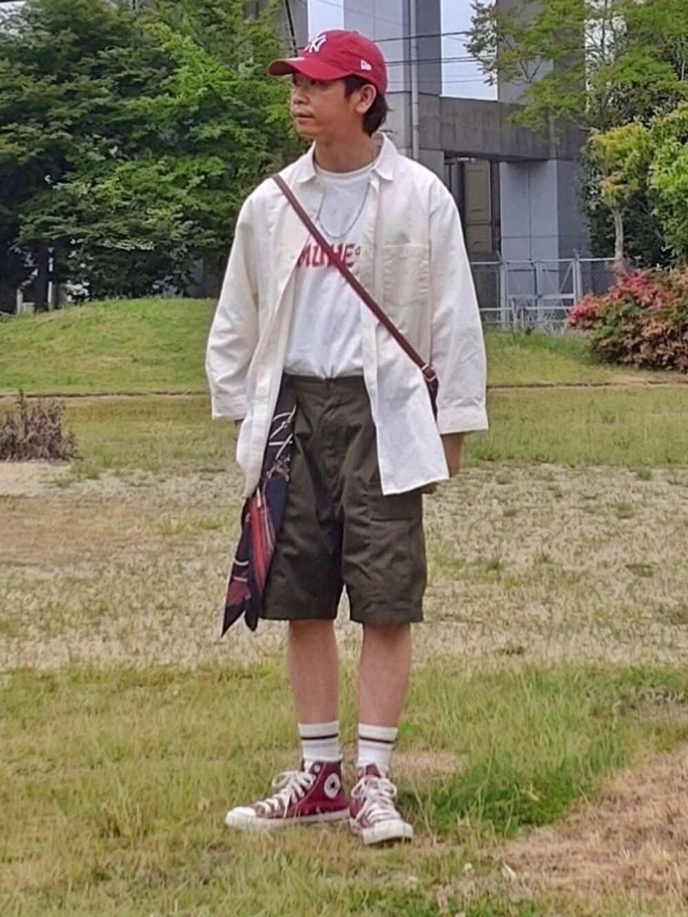 ホワイト系のTシャツ/カットソー、グリーン系のその他パンツ、レッド系のスニーカーを着用したメンズの夏コーディネートの2枚目の写真