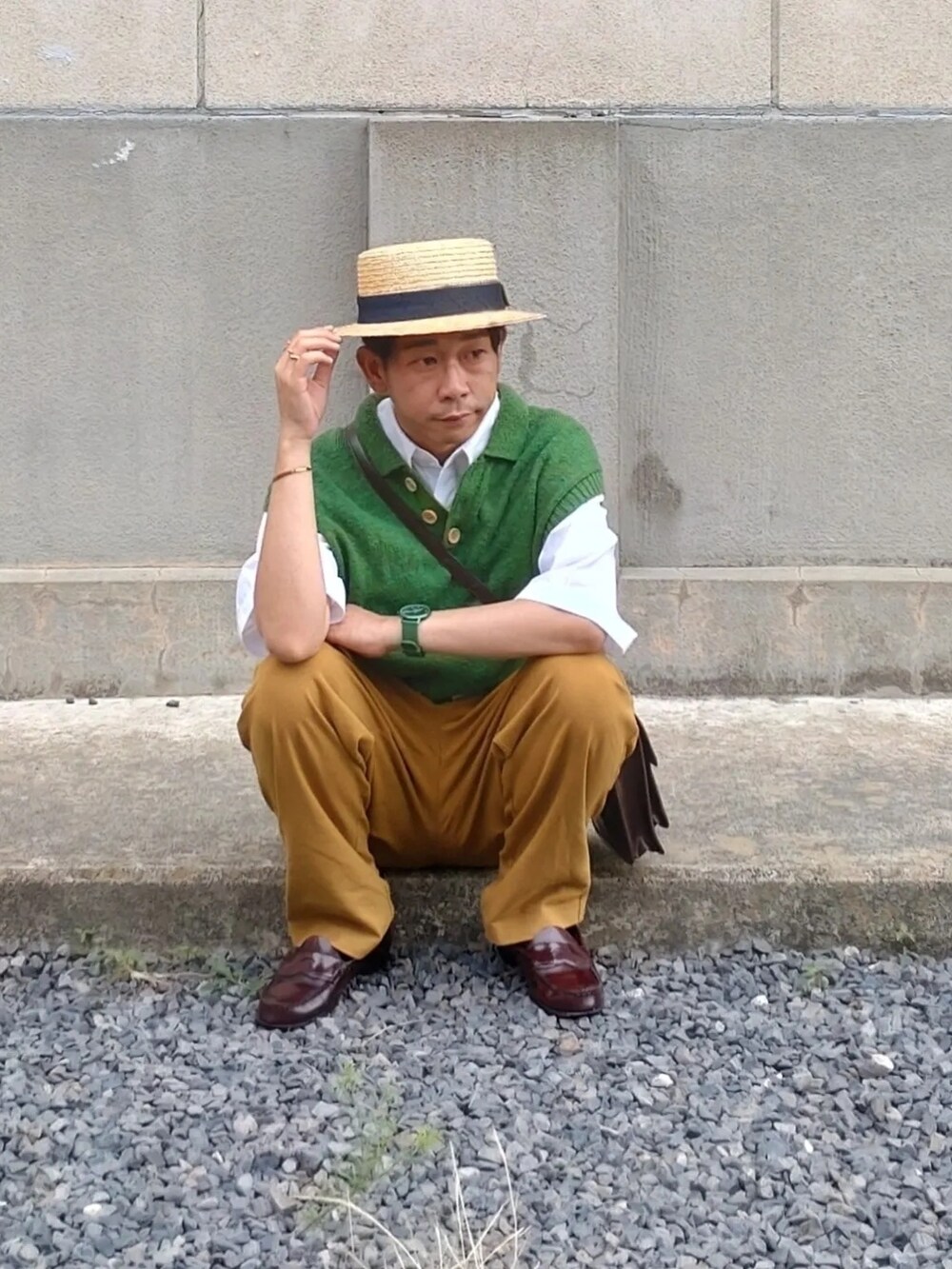 グリーン系のカーディガン/ボレロ、ブラウン系のショルダーバッグ、レッド系のローファーを着用したメンズの夏コーディネートの2枚目の写真