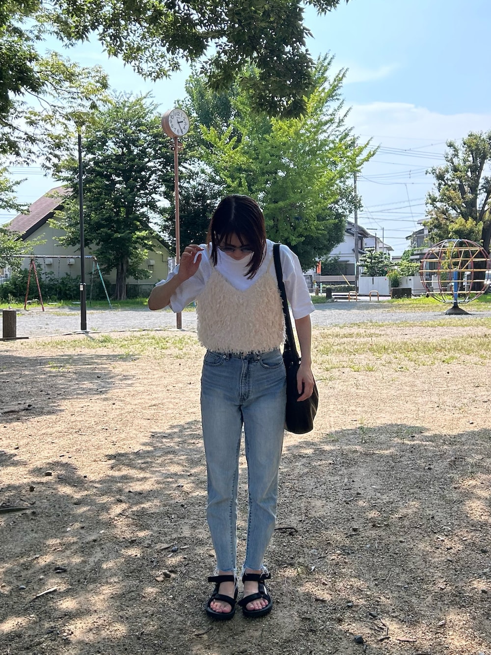 ホワイト系のシャツ/ブラウス、ブルー系のデニムパンツ、ブラック系のサンダルを着用したレディースの秋コーディネートの2枚目の写真