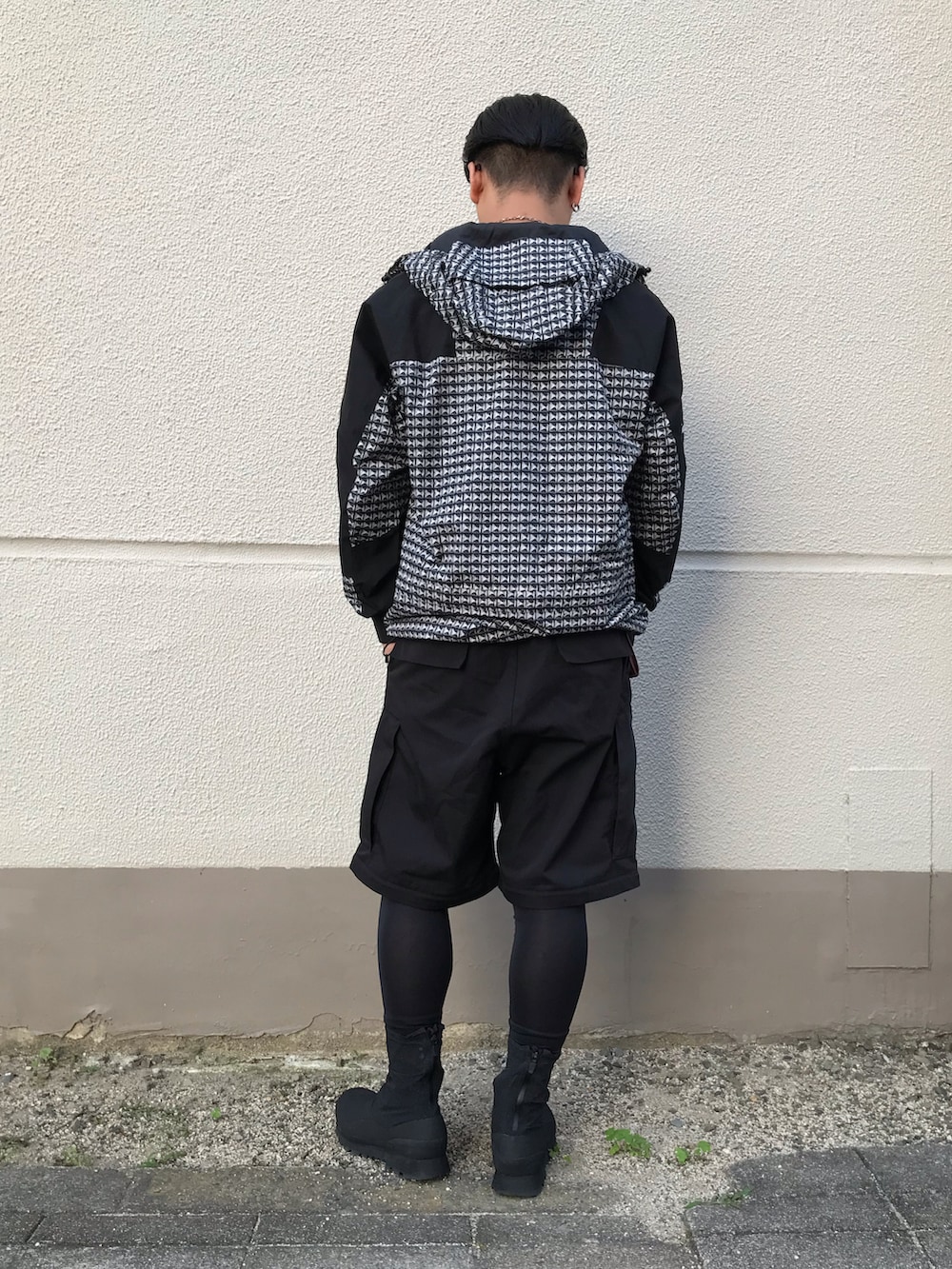 ブラック系のパンツ、ブラック系のレインシューズ、ブラック系のマウンテンパーカーを着用したメンズの夏コーディネートの2枚目の写真