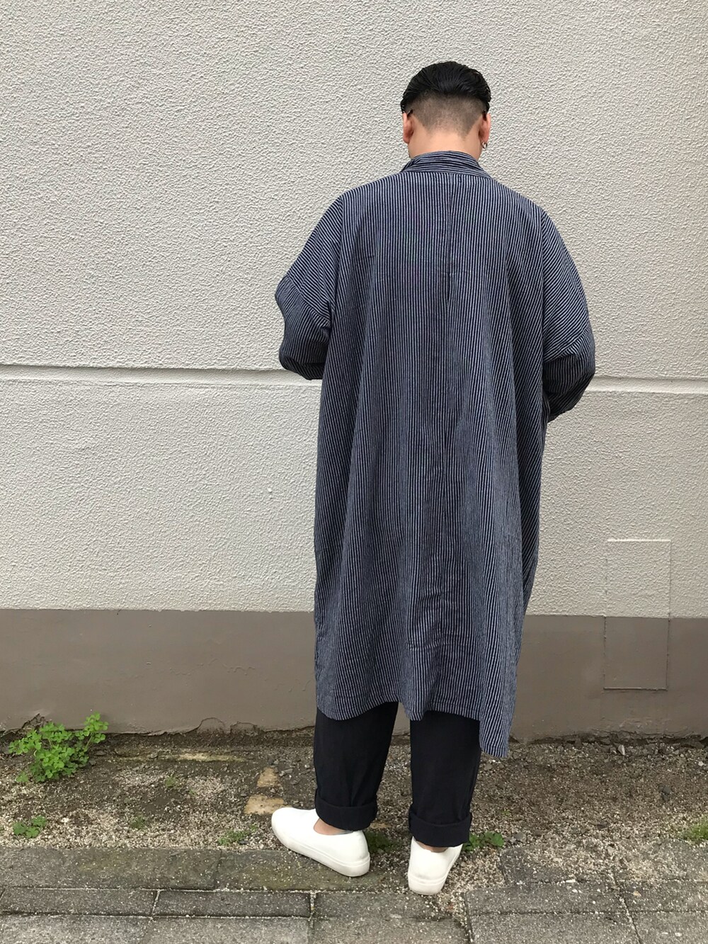 ブラック系のシャツワンピース、ブラック系のパンツ、ホワイト系のシューズを着用したメンズの春コーディネートの2枚目の写真