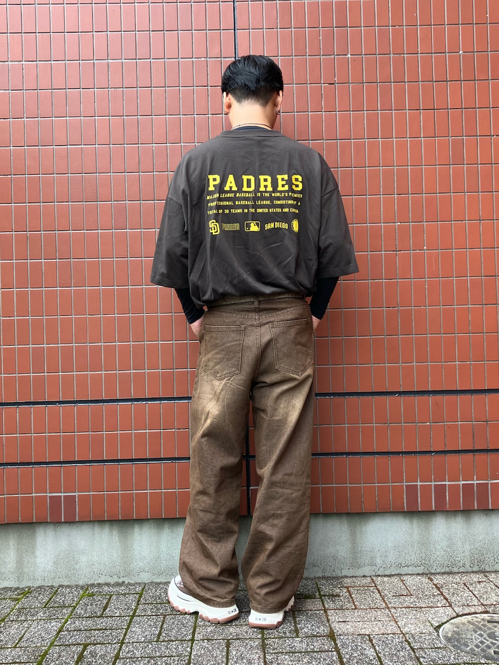 ブラウン系のTシャツ/カットソー、ブラウン系のデニムパンツ、ブラウン系のスニーカーを着用したメンズの春コーディネートの2枚目の写真