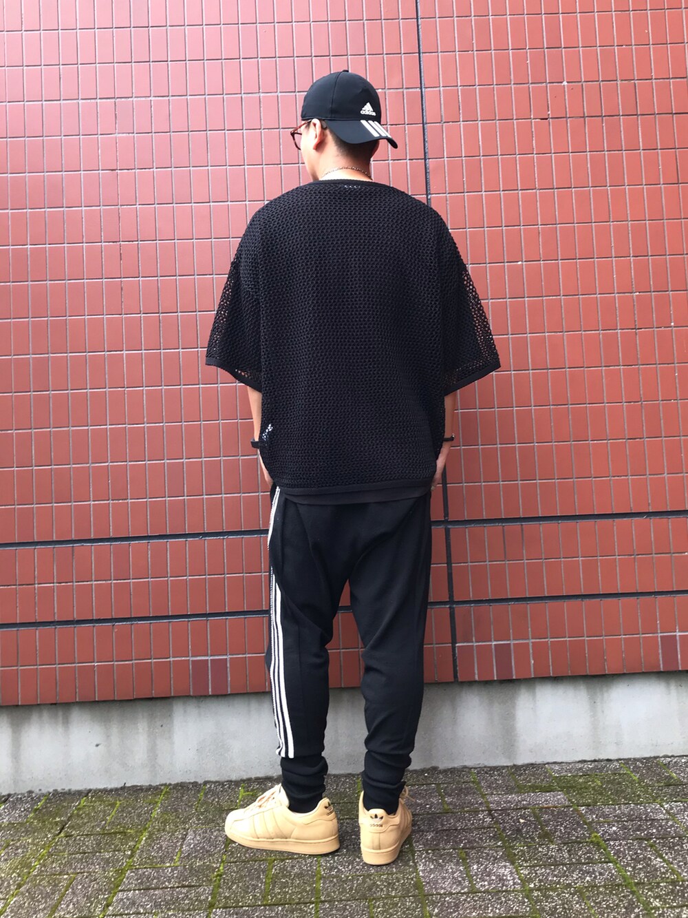 ブラック系のパンツ、ベージュ系のスニーカー、ブラック系のTシャツ/カットソーを着用したメンズの夏コーディネートの2枚目の写真