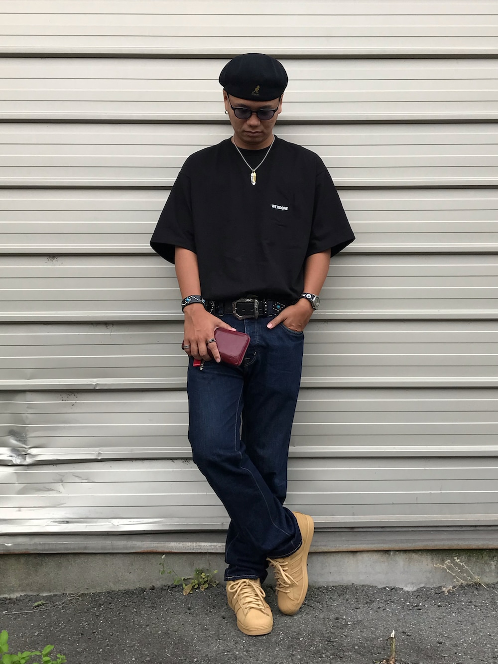 ベージュ系のスニーカー、ブルー系のデニムパンツ、ブラック系のTシャツ/カットソーを着用したメンズの夏コーディネートの2枚目の写真