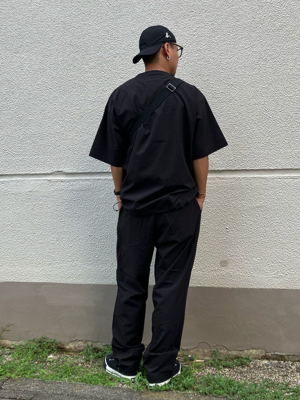 ブラック系のメッセンジャーバッグ、ブラック系のTシャツ/カットソー、ブラック系のその他パンツを着用したメンズの夏コーディネートの2枚目の写真