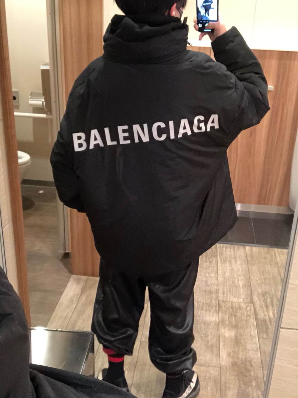 ブラック系のダウンジャケット/コート、ブラック系のパーカー、ブラック系のパンツを着用したメンズの冬コーディネートの2枚目の写真