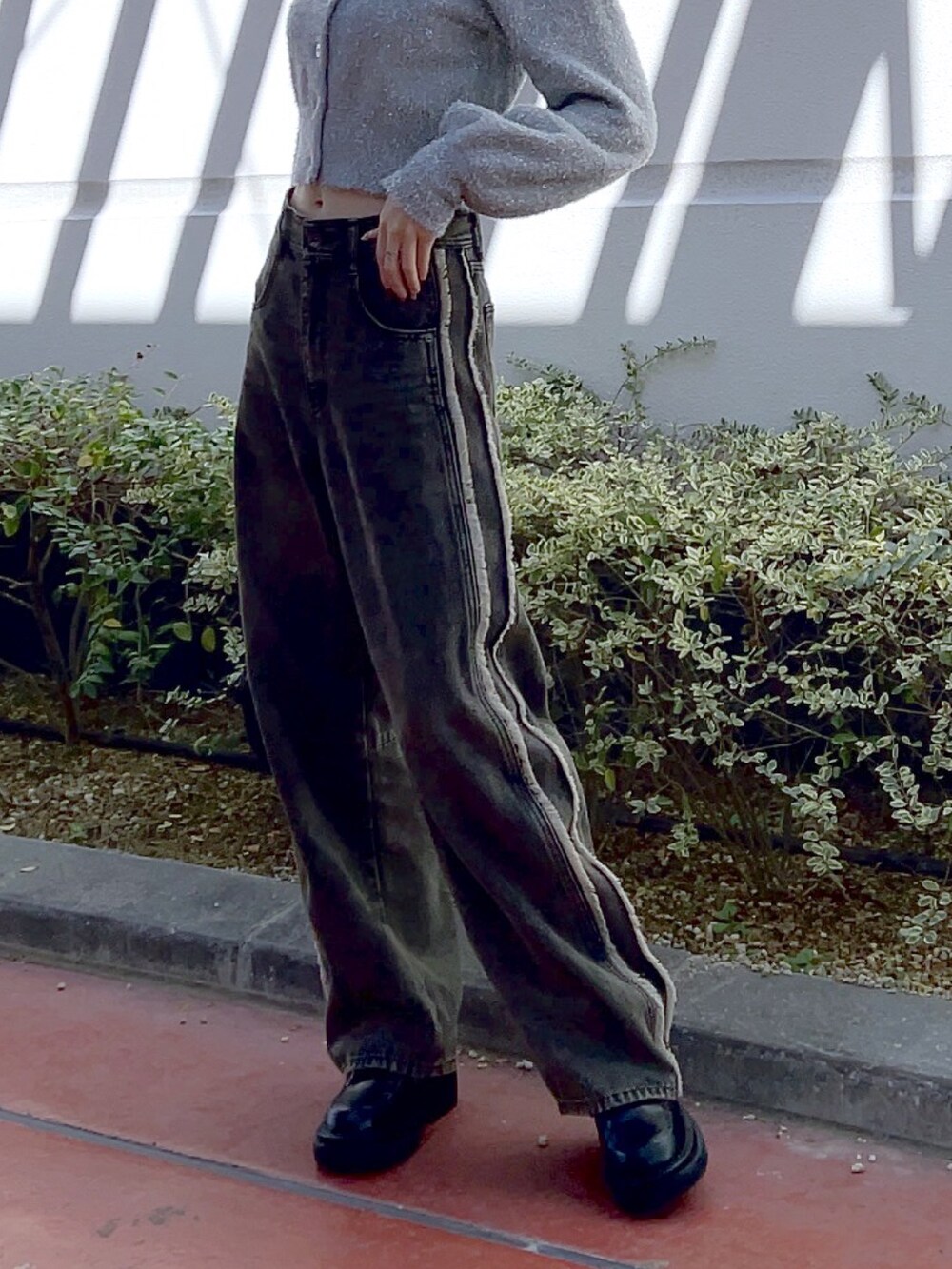 ホワイト系のブーツ、ブラック系のデニムパンツ、ホワイト系のトートバッグを着用したレディースの冬コーディネートの5枚目の写真