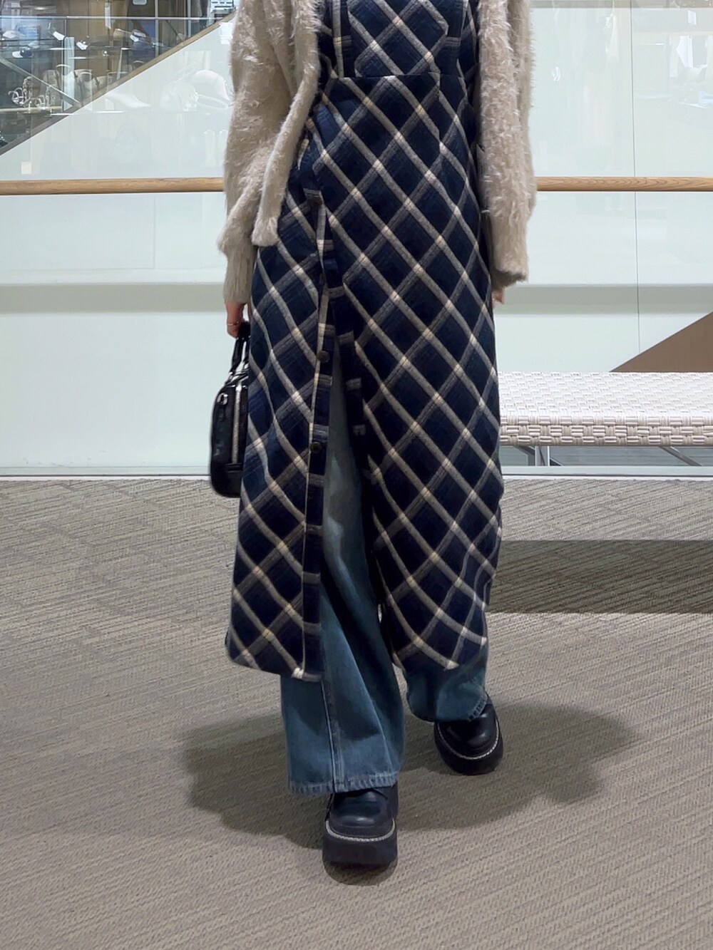 ブルー系のワンピース、ブルー系のデニムパンツ、ブラック系のショルダーバッグを着用したレディースの冬コーディネートの4枚目の写真