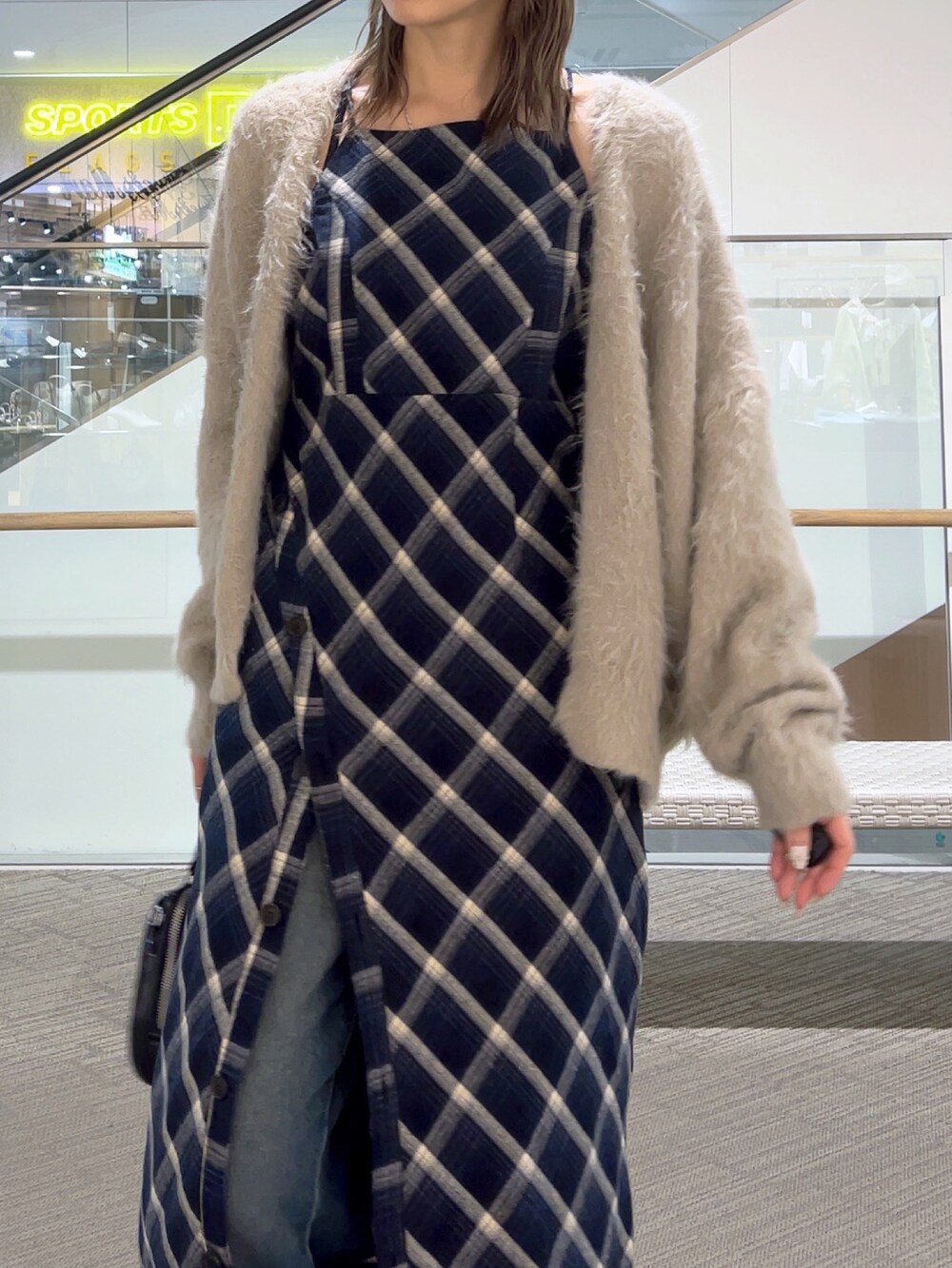 ブルー系のワンピース、ブルー系のデニムパンツ、ブラック系のショルダーバッグを着用したレディースの冬コーディネートの6枚目の写真