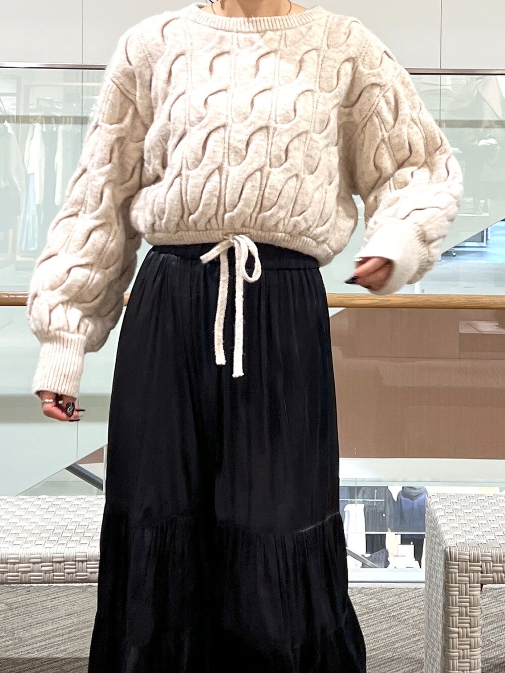 ブラック系のスカート、ブラウン系のニット/セーターを着用したレディースの冬コーディネートの2枚目の写真