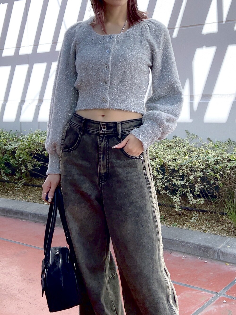 ホワイト系のブーツ、ブラック系のデニムパンツ、ホワイト系のトートバッグを着用したレディースの冬コーディネートの6枚目の写真