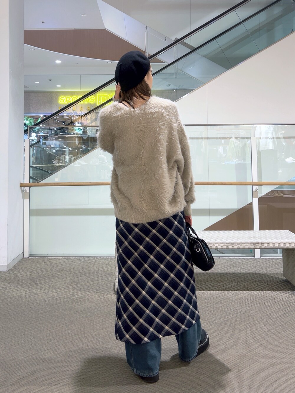 ブルー系のワンピース、ブルー系のデニムパンツ、ブラック系のショルダーバッグを着用したレディースの冬コーディネートの3枚目の写真