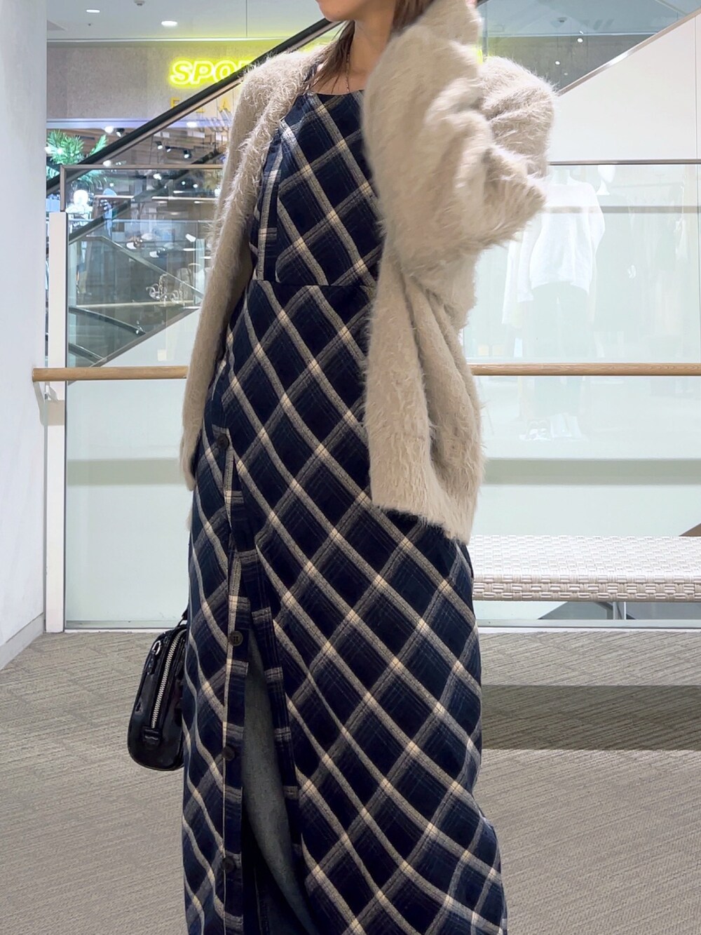 ブルー系のワンピース、ブルー系のデニムパンツ、ブラック系のショルダーバッグを着用したレディースの冬コーディネートの2枚目の写真