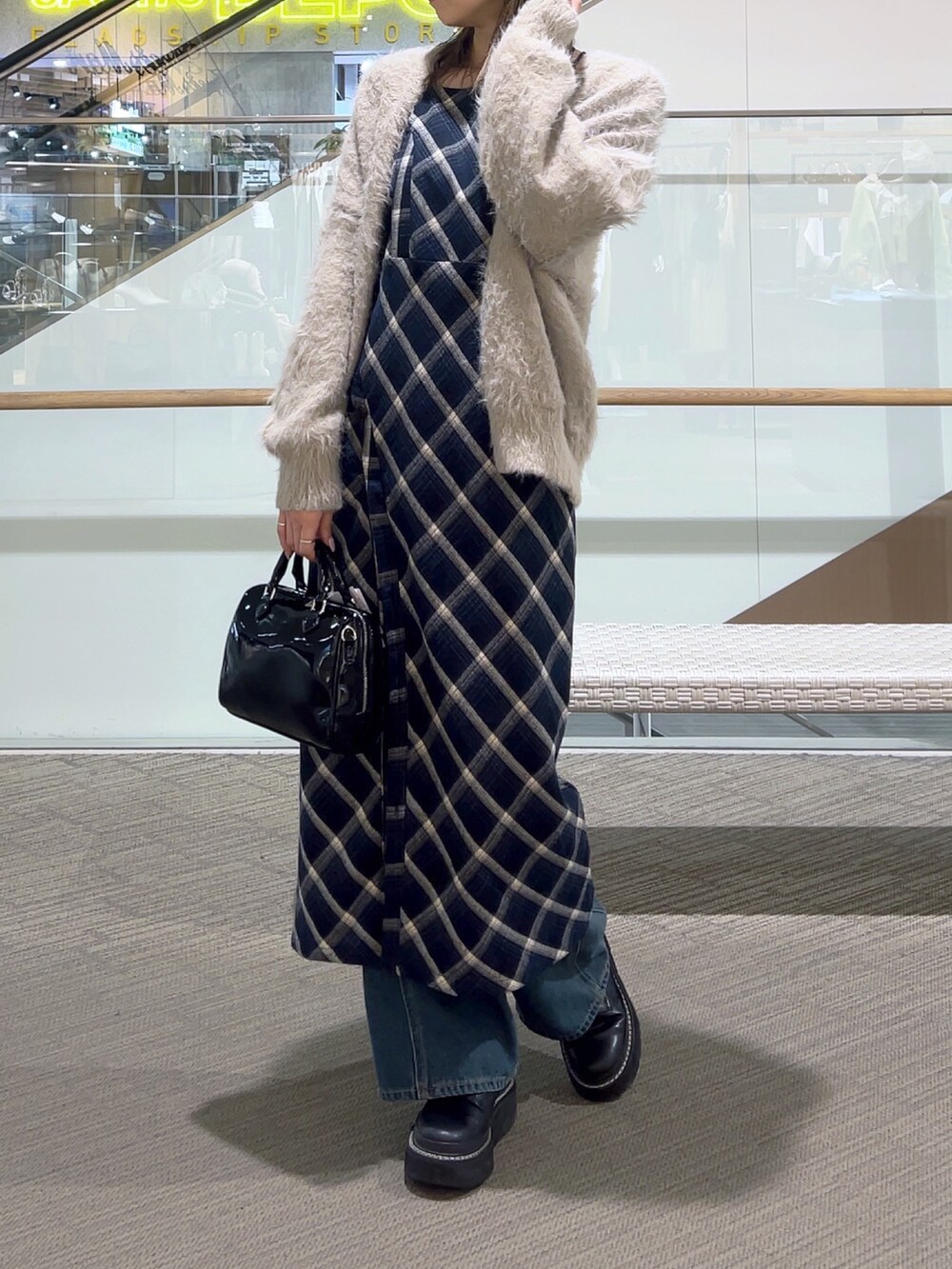 ブルー系のワンピース、ブルー系のデニムパンツ、ブラック系のショルダーバッグを着用したレディースの冬コーディネートの8枚目の写真