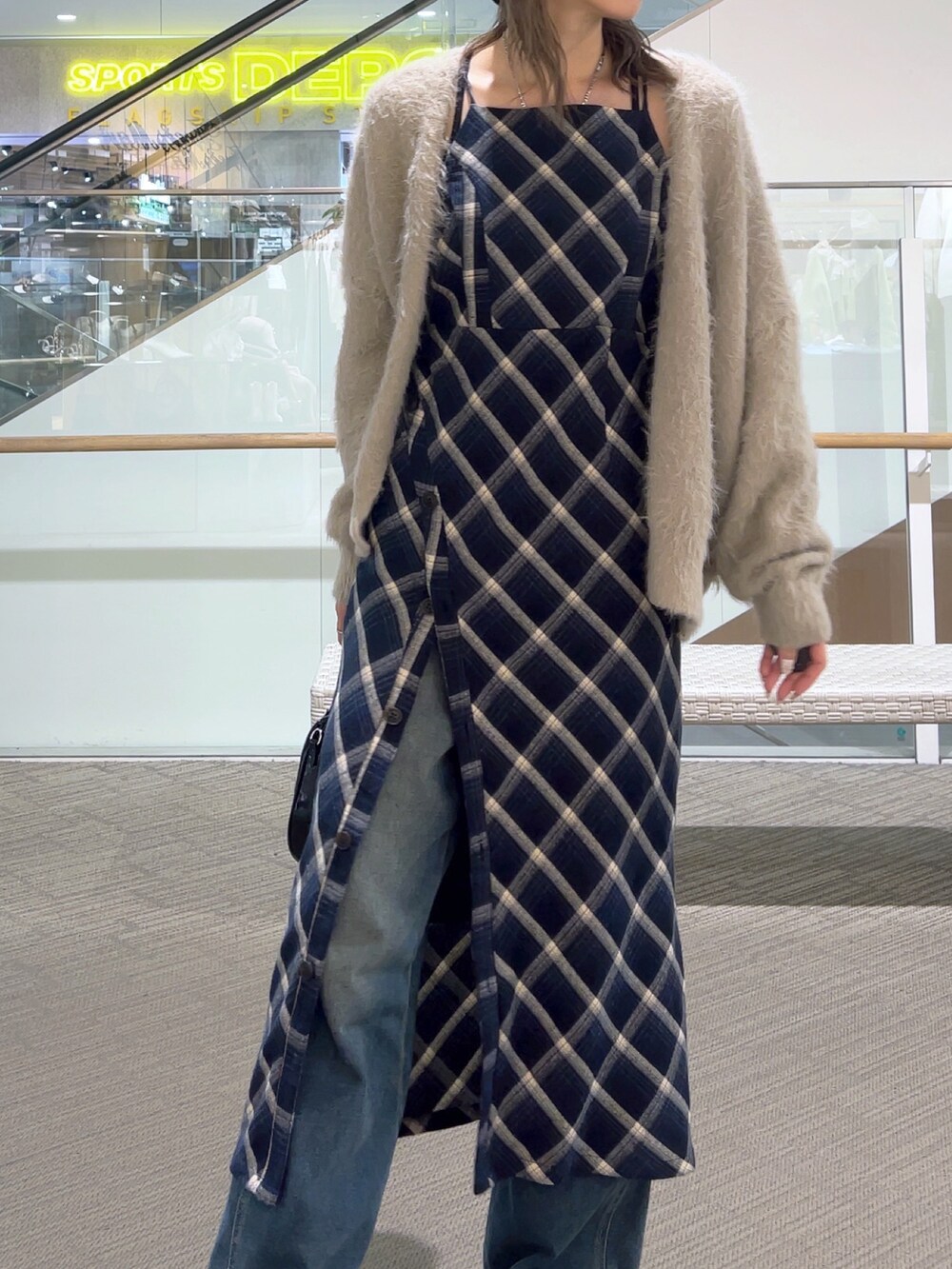 ブルー系のワンピース、ブルー系のデニムパンツ、ブラック系のショルダーバッグを着用したレディースの冬コーディネートの5枚目の写真