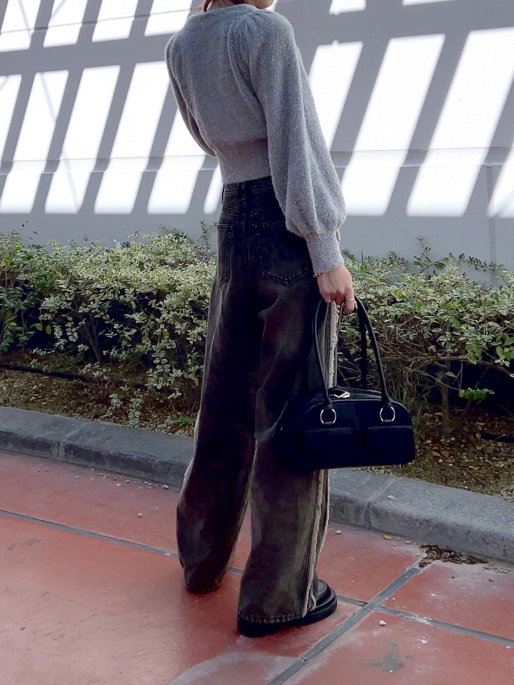 ホワイト系のブーツ、ブラック系のデニムパンツ、ホワイト系のトートバッグを着用したレディースの冬コーディネートの4枚目の写真