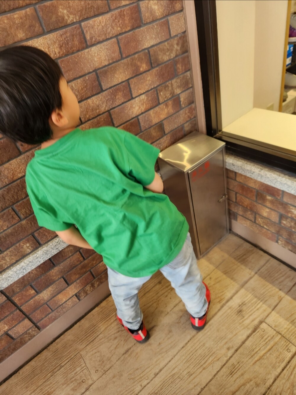 グリーン系のTシャツ/カットソー、ブルー系のデニムパンツ、ブラック系のスニーカーを着用したキッズの春コーディネートの2枚目の写真