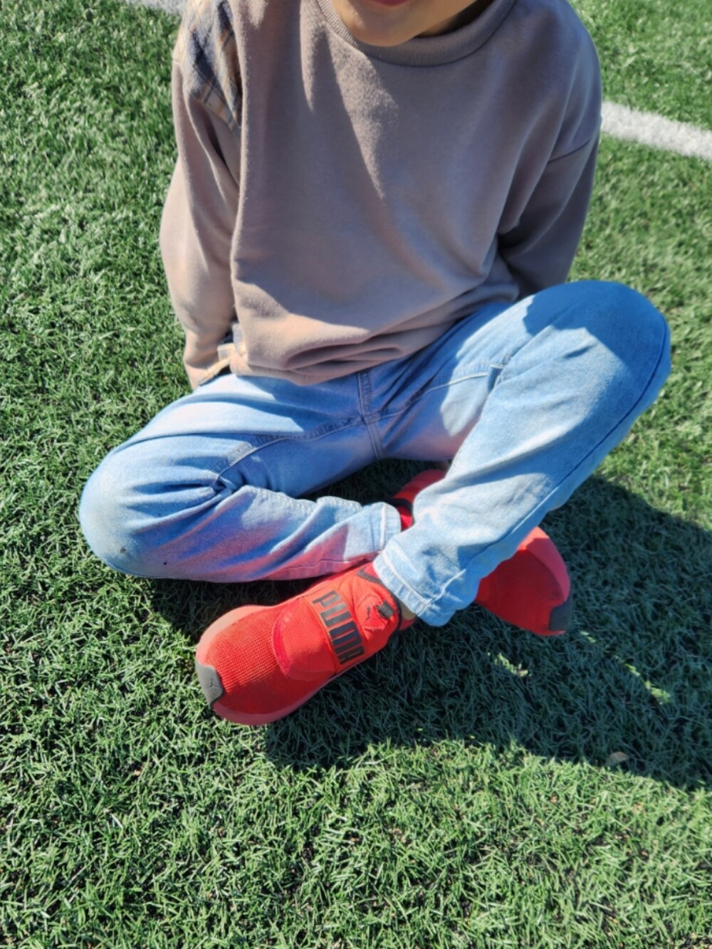 ブルー系のスウェット、ブルー系のデニムパンツ、レッド系のスニーカーを着用したキッズの秋コーディネートの3枚目の写真