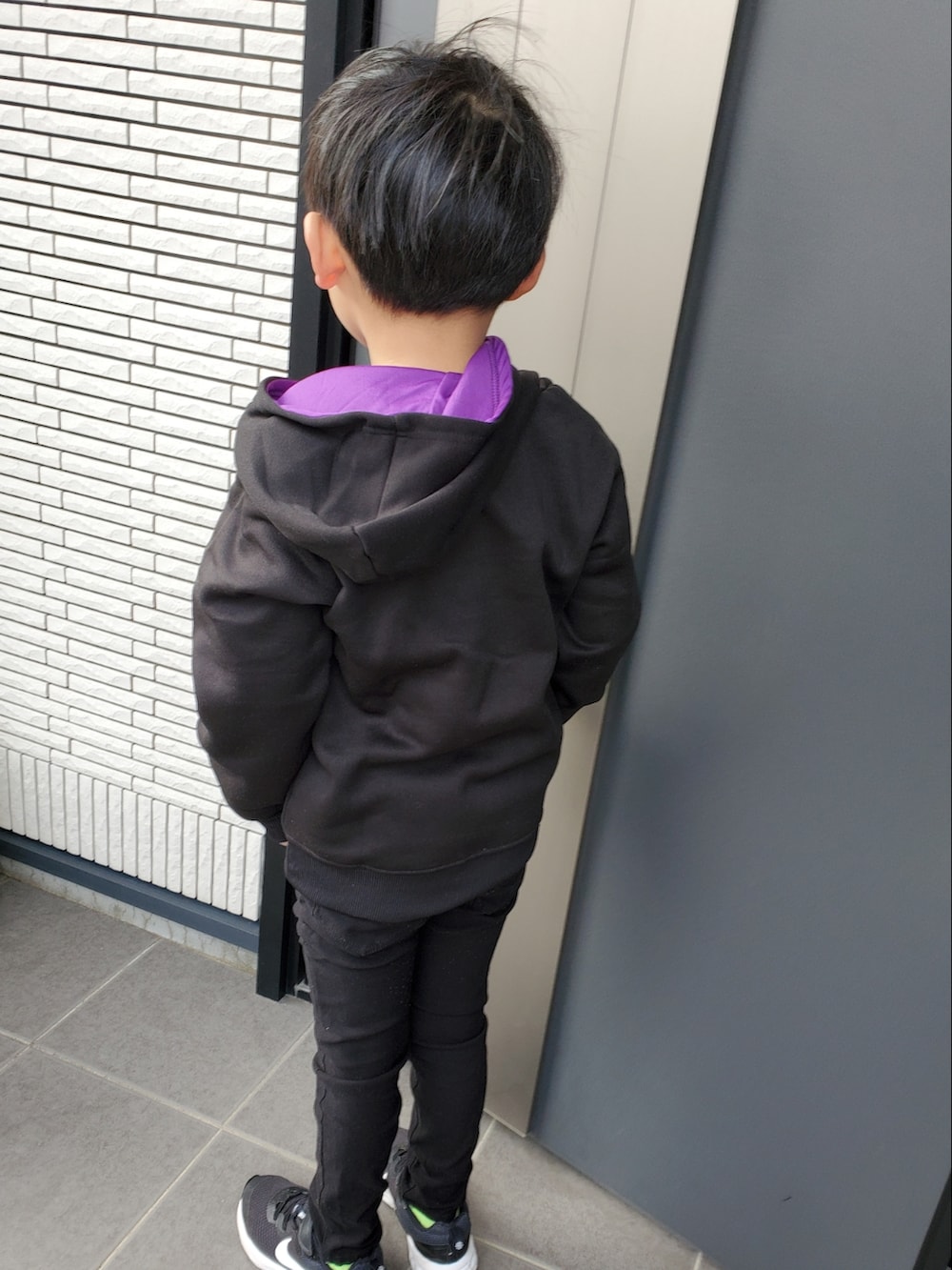 ブラック系のパーカー、ブラック系のカーゴパンツ、ブラック系のスニーカーを着用したキッズの冬コーディネートの2枚目の写真