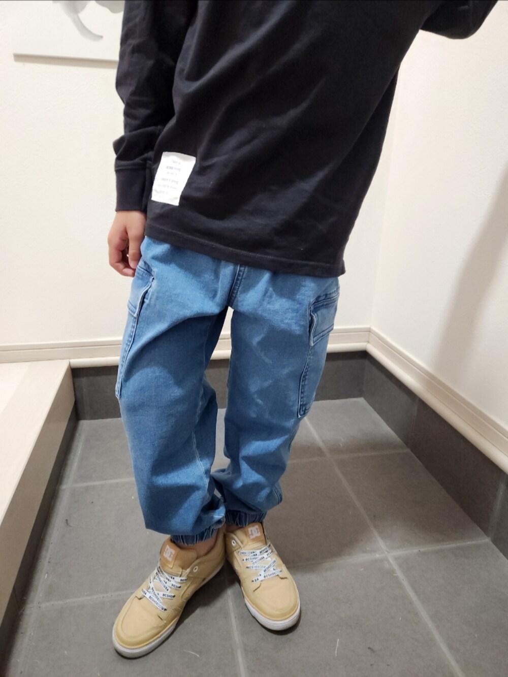 ベージュ系のスニーカー、ブラック系のTシャツ/カットソー、ブルー系のカーゴパンツを着用したキッズの春コーディネートの2枚目の写真