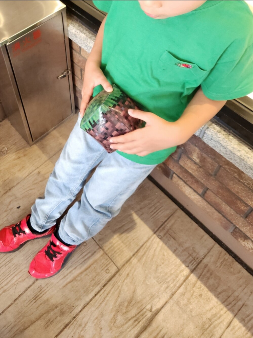 グリーン系のTシャツ/カットソー、ブルー系のデニムパンツ、ブラック系のスニーカーを着用したキッズの春コーディネートの3枚目の写真