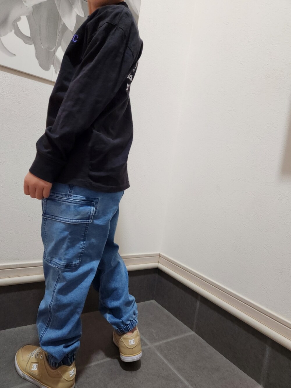 ベージュ系のスニーカー、ブラック系のTシャツ/カットソー、ブルー系のカーゴパンツを着用したキッズの春コーディネートの3枚目の写真