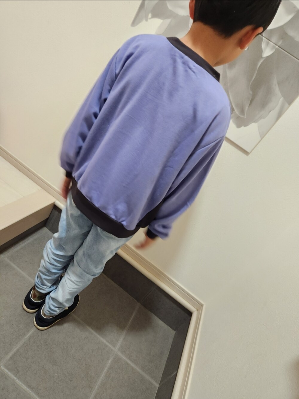 パープル系のスウェット、ブルー系のデニムパンツ、ブラック系のスリッポンを着用したキッズの冬コーディネートの2枚目の写真