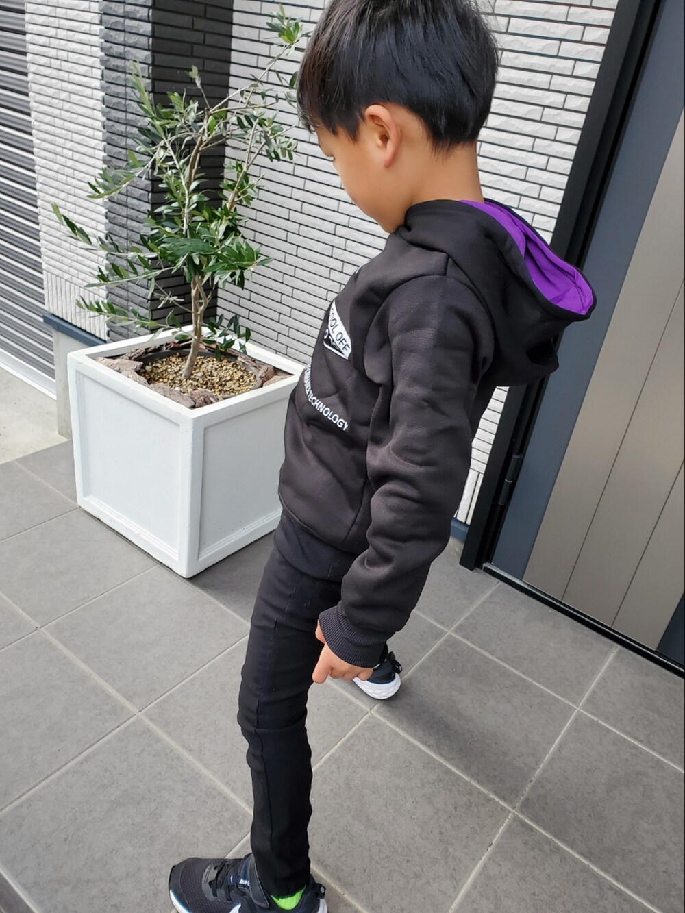 ブラック系のパーカー、ブラック系のカーゴパンツ、ブラック系のスニーカーを着用したキッズの冬コーディネートの3枚目の写真