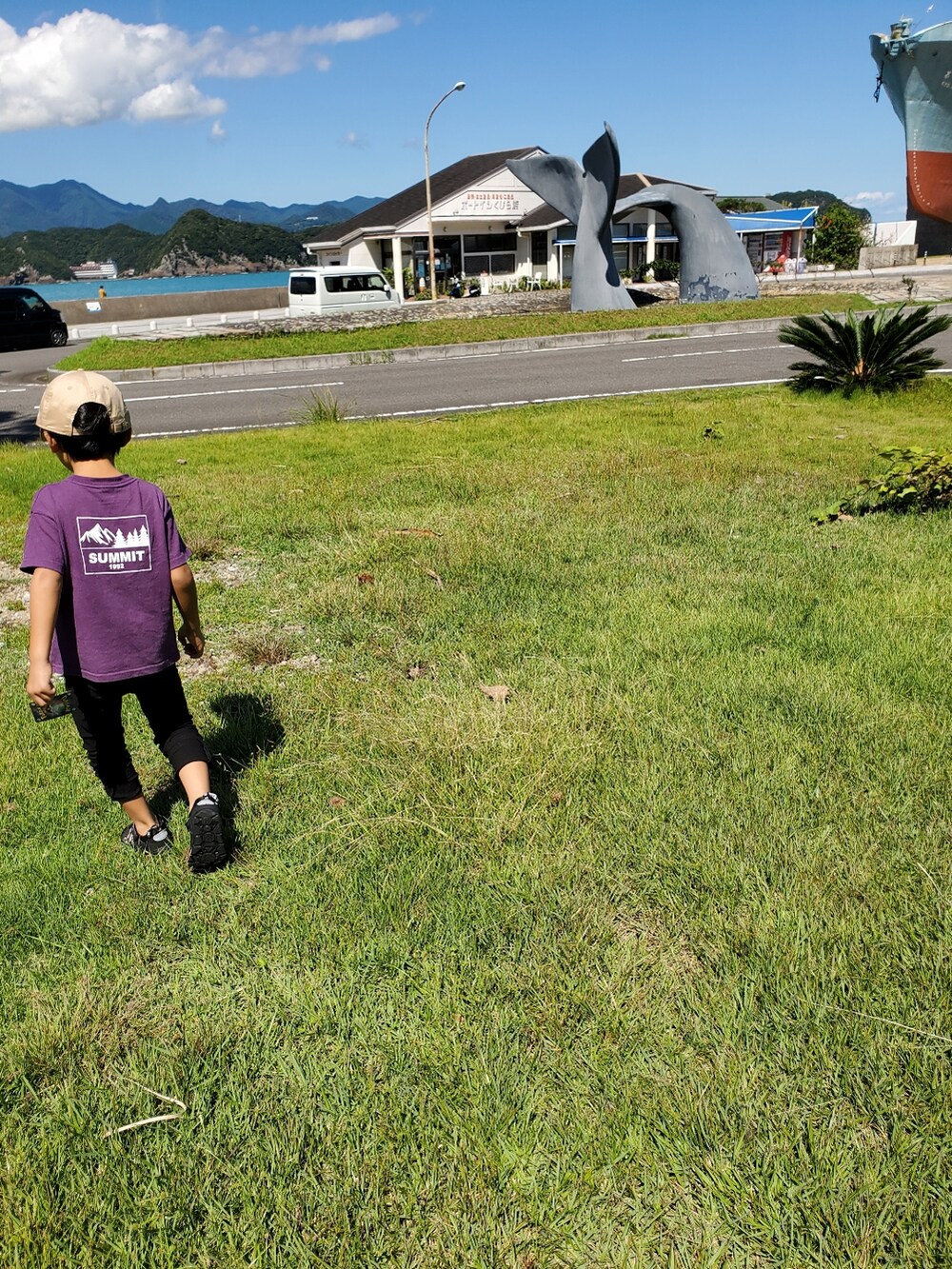 ブラック系のカーゴパンツ、ブラック系のサンダル、パープル系のTシャツ/カットソーを着用したキッズの秋コーディネートの2枚目の写真