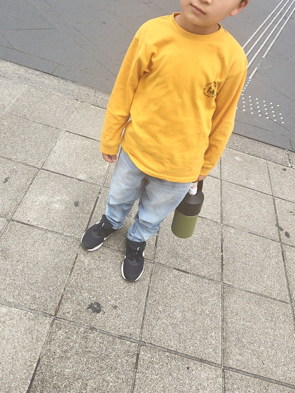 イエロー系のTシャツ/カットソー、ブラック系のスニーカーを着用したキッズの春コーディネートの2枚目の写真