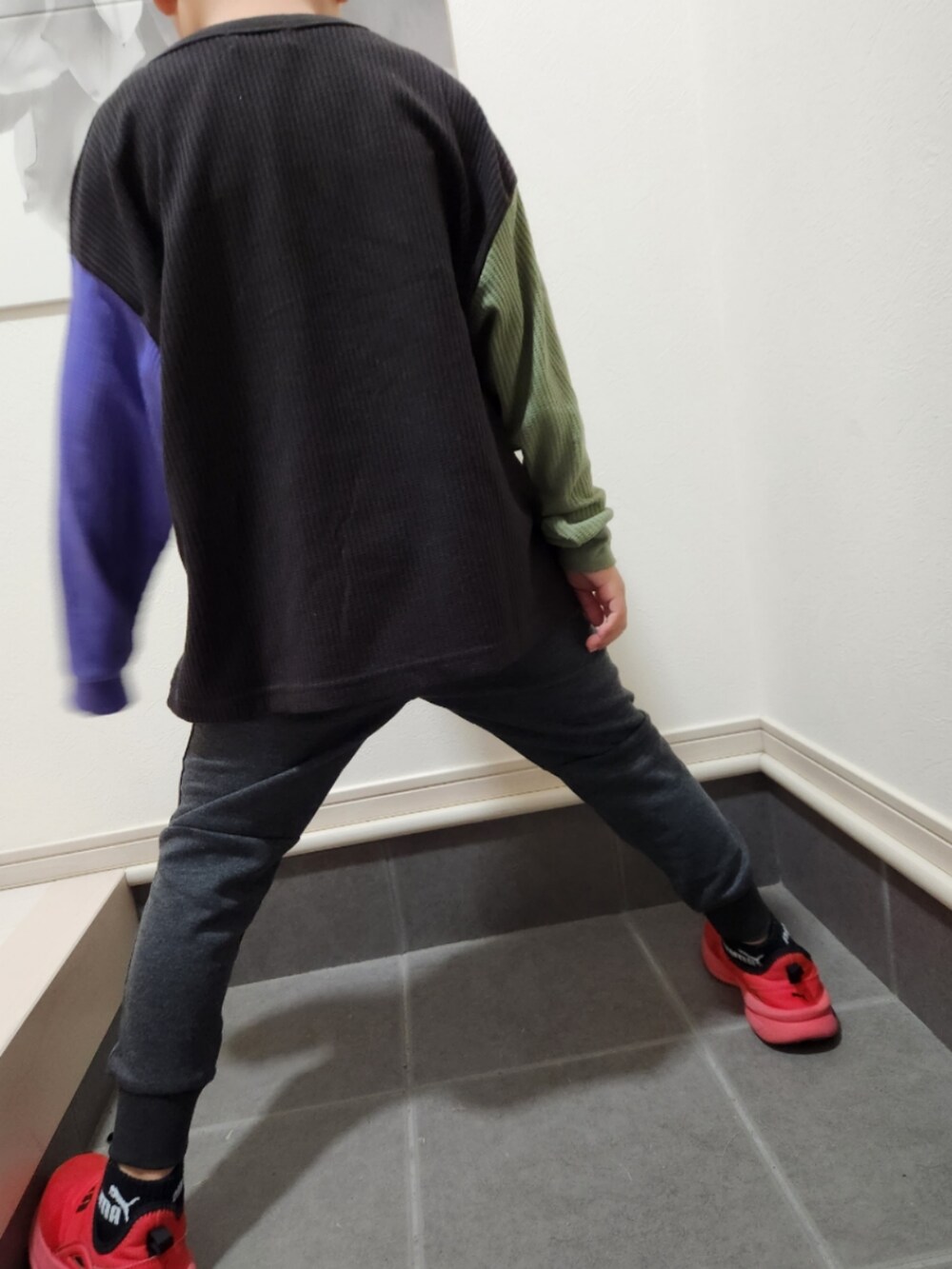 グレー系のスウェットパンツ、ブラック系のTシャツ/カットソー、レッド系のスニーカーを着用したキッズの秋コーディネートの3枚目の写真