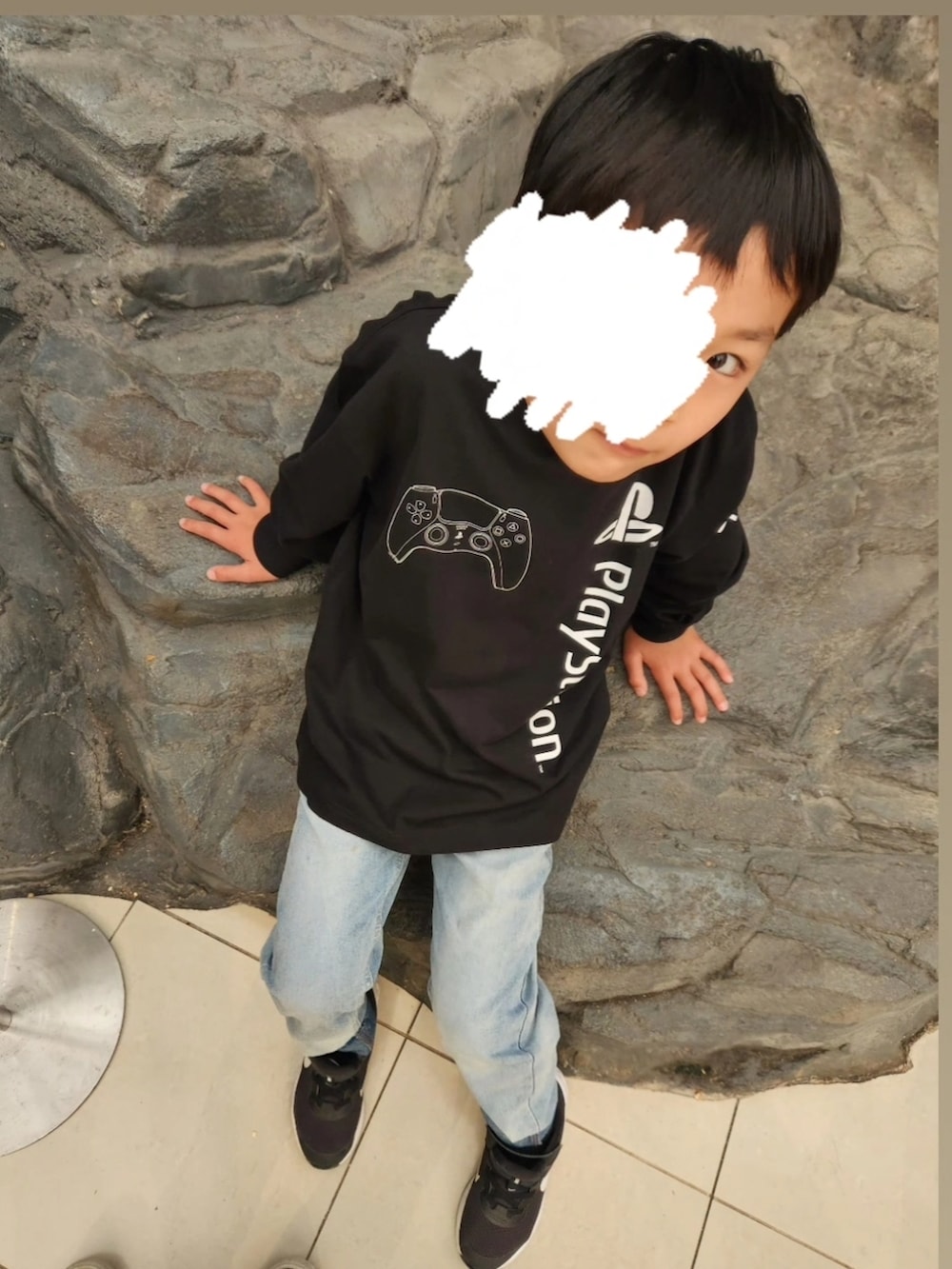 ブラック系のTシャツ/カットソー、ブルー系のデニムパンツ、ブラック系のスニーカーを着用したキッズの春コーディネートの2枚目の写真