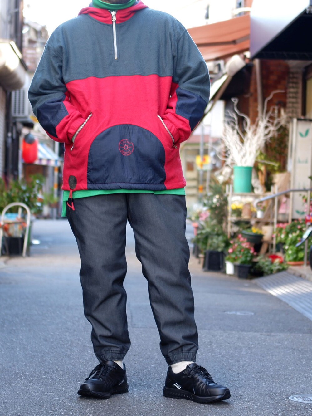 グレー系のパンツ、ブラック系のスニーカー、レッド系のジャケット/アウターを着用したメンズの冬コーディネートの3枚目の写真