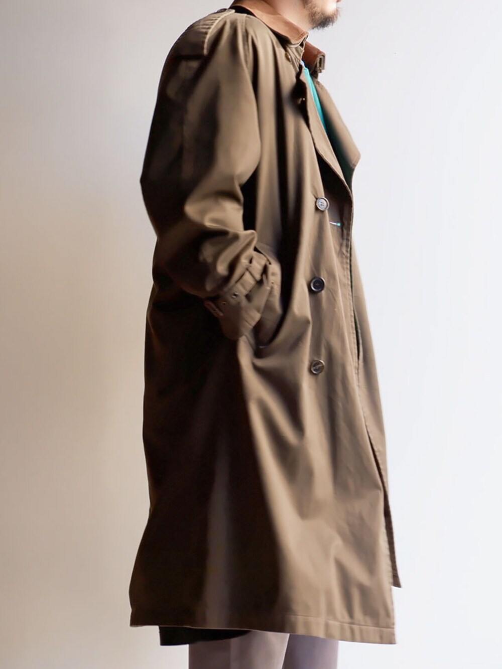 グリーン系のスウェット、グレー系のパンツ、ブラック系のスニーカーを着用したメンズの冬コーディネートの2枚目の写真