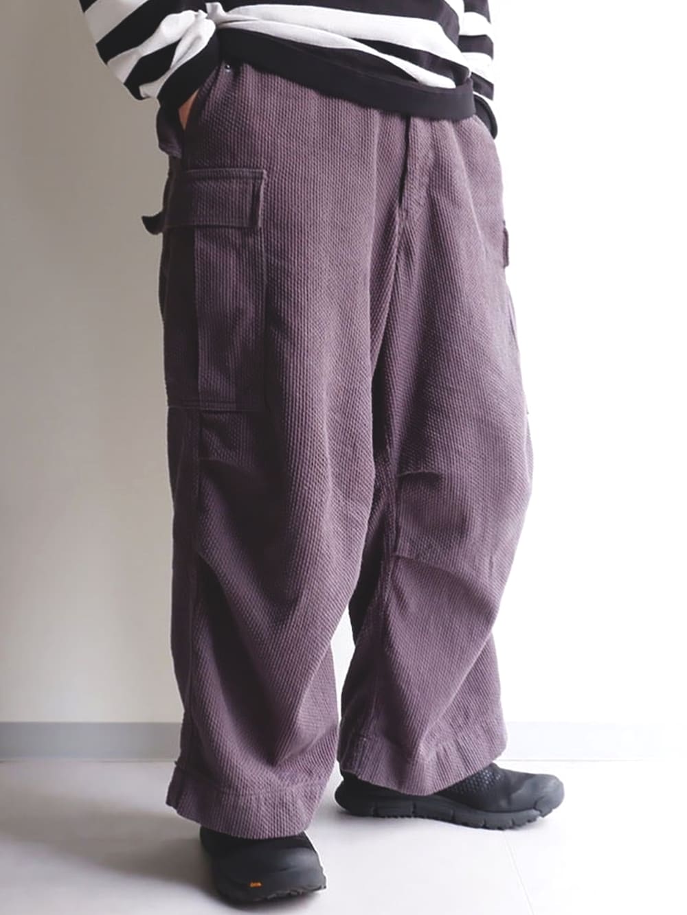 グレー系のカーゴパンツ、ブラック系のジャケット/アウター、ブラック系のスニーカーを着用したメンズの春コーディネートの2枚目の写真