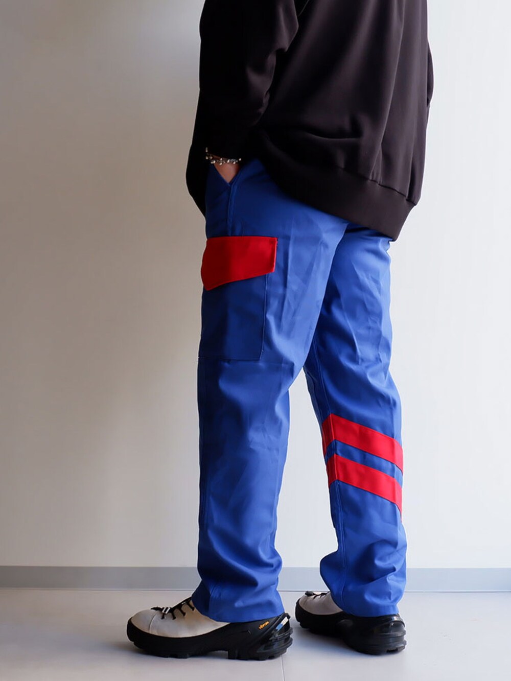 ブルー系のパンツ、ブラック系のスウェット、ホワイト系のブーツを着用したメンズの夏コーディネートの3枚目の写真