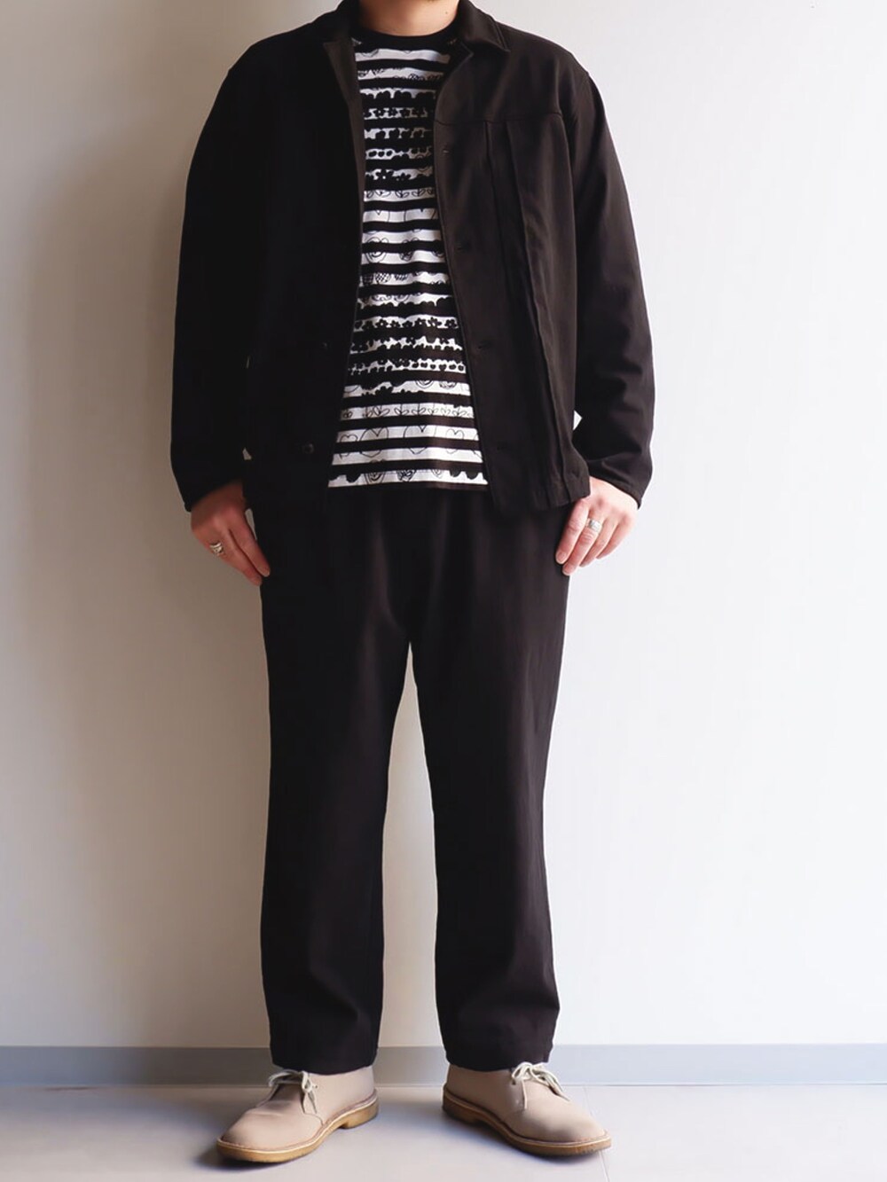 ブラック系のシャツ/ブラウス、ブラック系のパンツ、ベージュ系のブーツを着用したメンズの春コーディネートの2枚目の写真