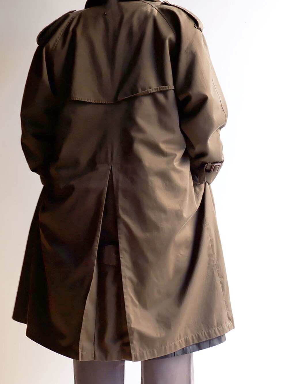 グリーン系のスウェット、グレー系のパンツ、ブラック系のスニーカーを着用したメンズの冬コーディネートの3枚目の写真