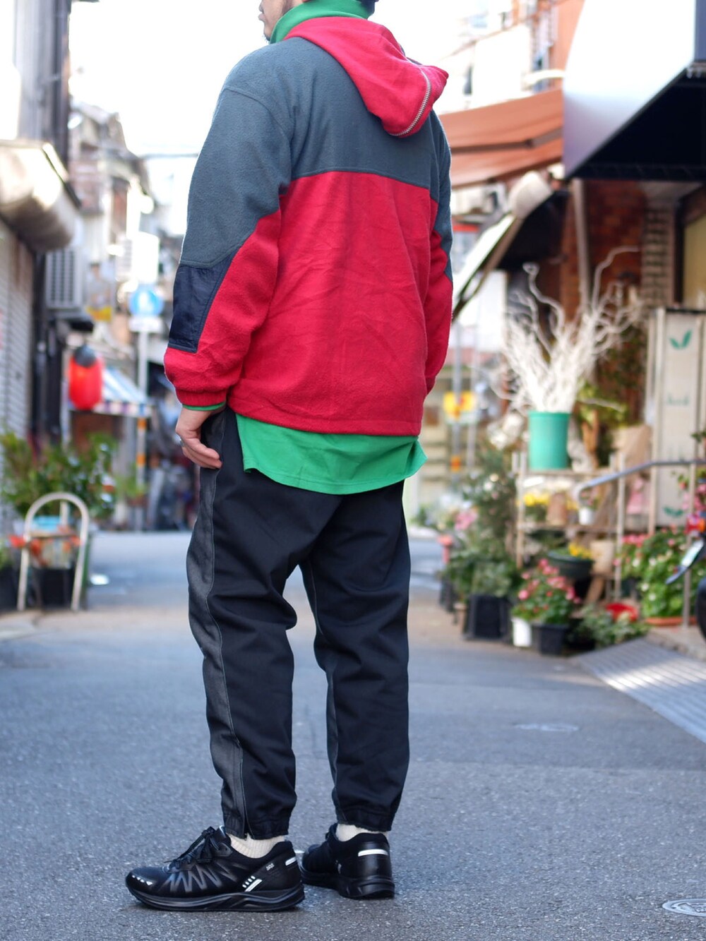 グレー系のパンツ、ブラック系のスニーカー、レッド系のジャケット/アウターを着用したメンズの冬コーディネートの2枚目の写真