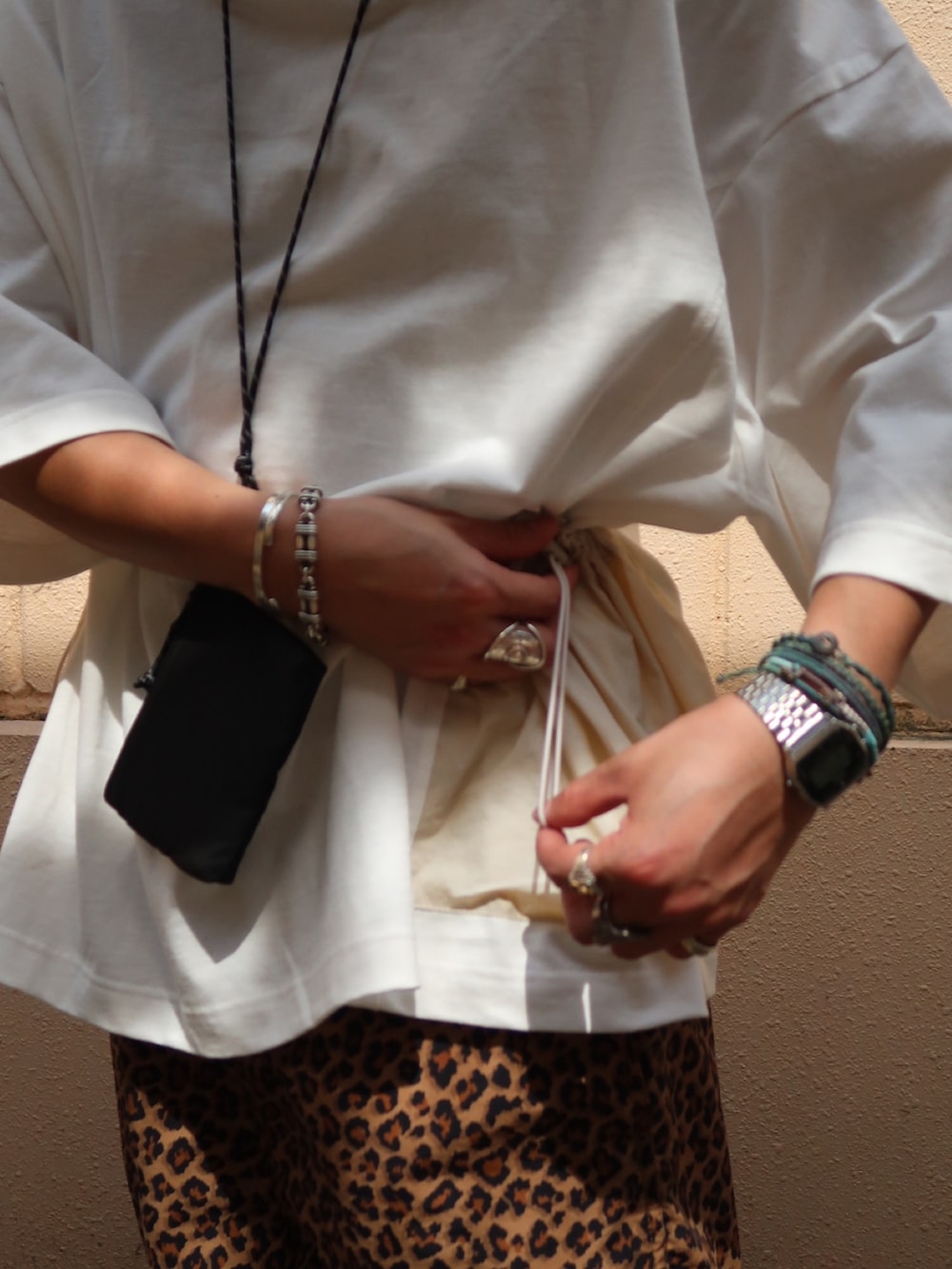 ホワイト系のTシャツ/カットソー、ブラック系のショルダーバッグ、ブラック系のサンダルを着用したメンズの夏コーディネートの5枚目の写真