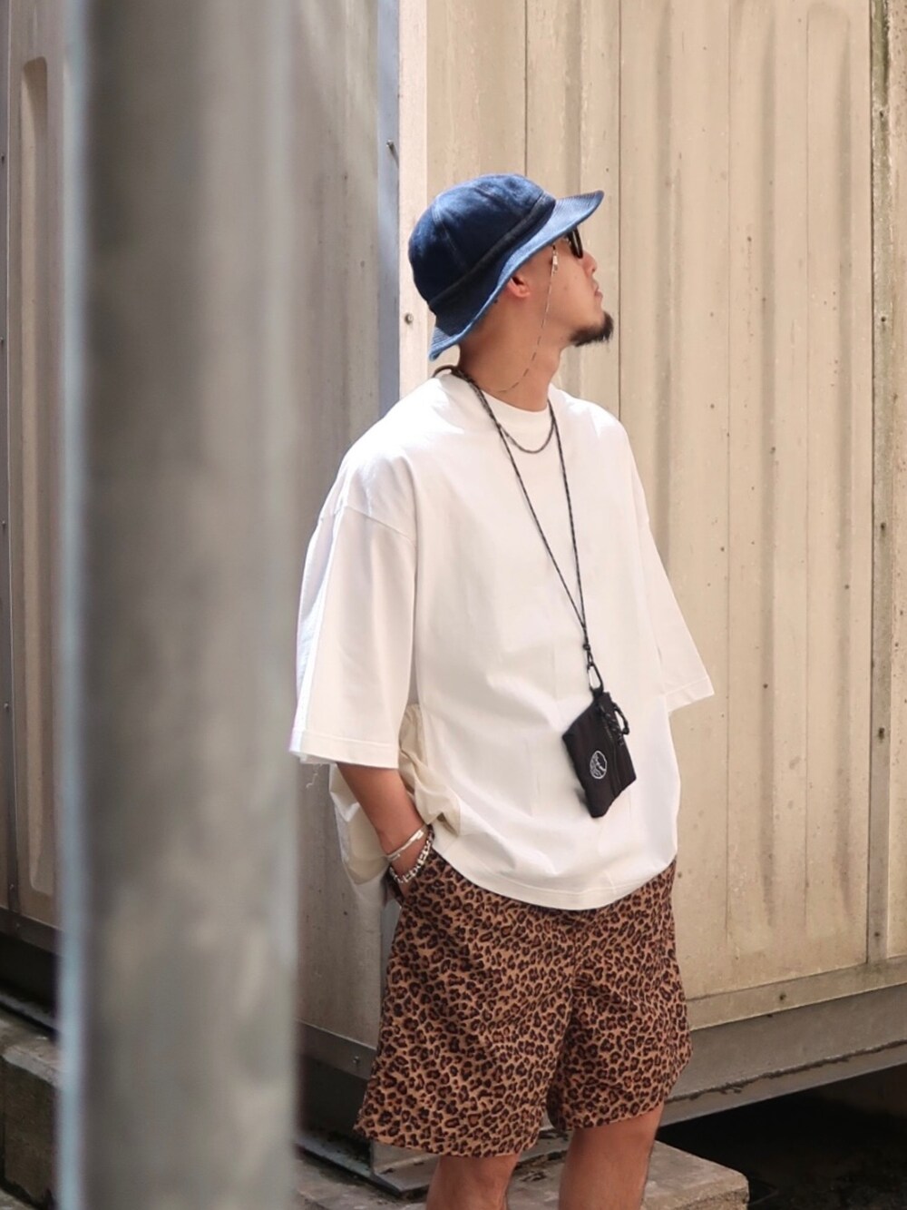 ホワイト系のTシャツ/カットソー、ブラック系のショルダーバッグ、ブラック系のサンダルを着用したメンズの夏コーディネートの2枚目の写真