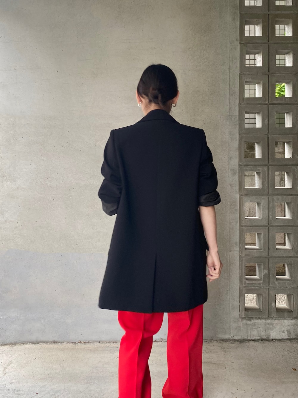 ブラック系のテーラードジャケット、レッド系のその他パンツ、ベージュ系のメガネを着用したレディースの春コーディネートの3枚目の写真